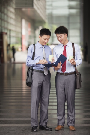 Two young businessmen working outdoorの写真素材