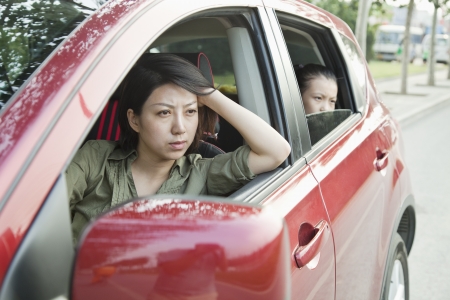 Mother and Daughter Looking Frustrated Out the Window of a Carの写真素材