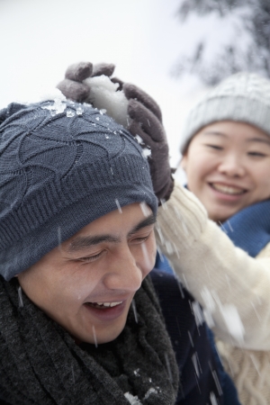 Young Couple Having a Snowball Fightの写真素材