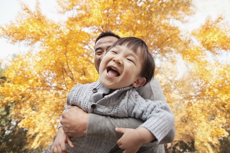 Father and Son Playing a Park in Autumn