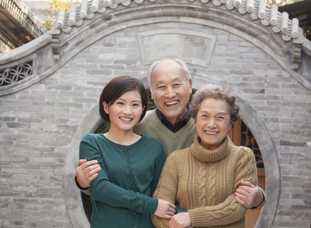 Grandparents and granddaughter in front of round arch, Beijing