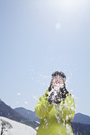 Young Woman Playing with Snow in the Mountainsの写真素材