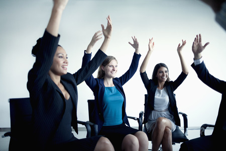 Business people cheering with arms in the airの写真素材