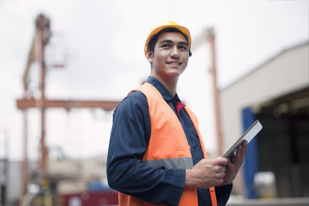 Proud young worker in protective work wear in a shipping yardの写真素材