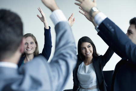 Business people cheering with arms in the airの写真素材