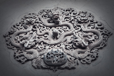 Ornate low relief sculpture of dragon on wall.の写真素材
