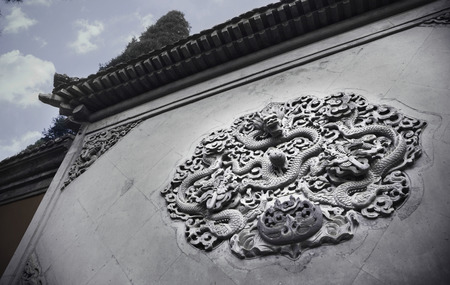 Ornate low relief sculpture of dragon on wall.の写真素材