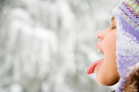 Girl in snow sticking out tongueの写真素材