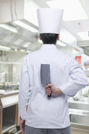 Rear View of Chef with Knife Behind his Backの写真素材