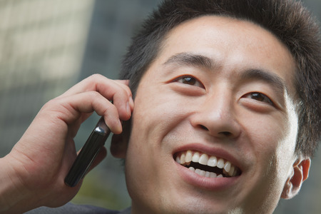 Portrait of young man on the phone, close up     の写真素材
