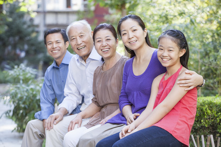 Three Generation Family Sitting in their Apartment Courtyard
