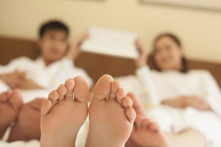 Family in Bed with Bare Feetの写真素材