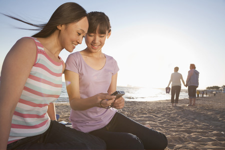 Mother and Daughter looking at camera on the beachの写真素材