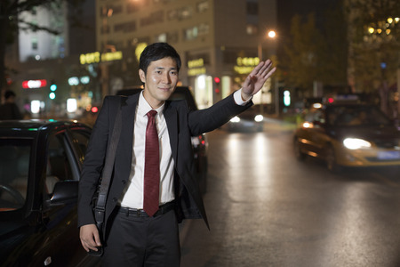 Businessman Hailing Taxi Cabの写真素材
