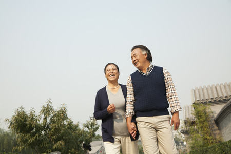 Senior couple going for a stroll in Beijing, holding handsの写真素材