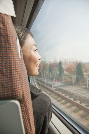 Young Woman Looking Out the Window of a Trainの写真素材