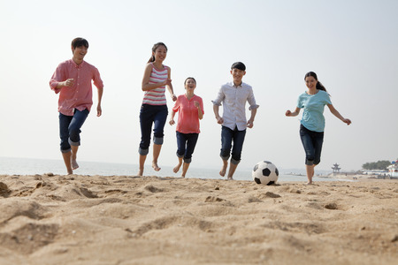 Young Friends Playing Soccer on the Beachの写真素材