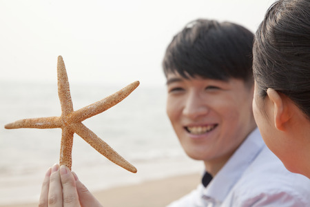 Young Friends Looking at Starfishの写真素材