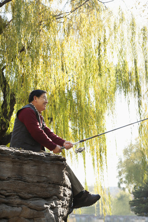 Senior fishing at lakeの写真素材