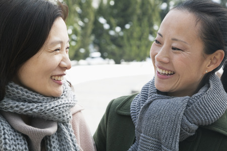 Two friends in park covered in snow, portraitの写真素材