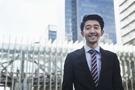 Portrait of smiling young businessman outdoors in Beijing, Chinaの写真素材