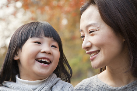 Close-up of Mother and Daughter laughing in the park, autumn, Chinaの写真素材