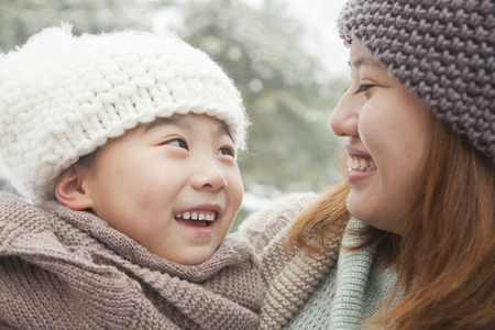 Mother and daughter looking at each other in winterの写真素材