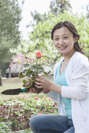 Portrait of woman planting flowers. の写真素材