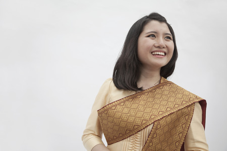 Portrait of smiling young woman in traditional clothing from Laos, studio shotの写真素材
