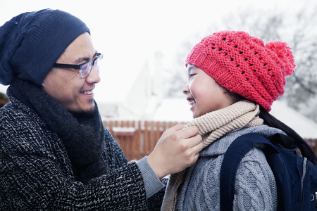 Father fixing daughter's scarfの写真素材
