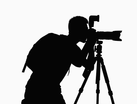Silhouette of man taking pictures with camera on tripod.の写真素材