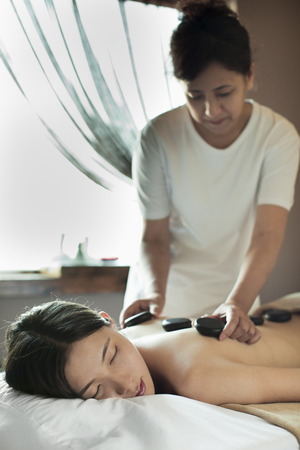 Young Woman Receiving Hot Stone Massageの写真素材
