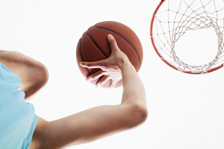 Man attempting to through basketball in to the basketの写真素材
