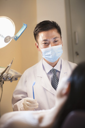 Male Dentist Examining Female Patientの写真素材