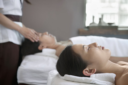 Mother and Daughter Having Head Massage Togetherの写真素材