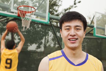 Teammates playing basketball の写真素材