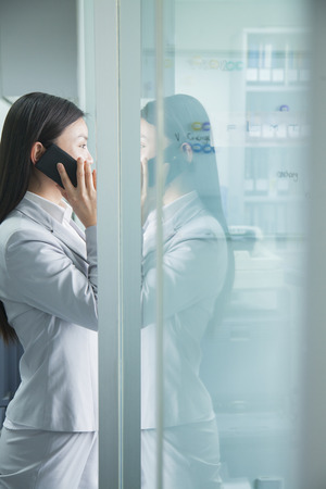 Businesswoman On Phone Reflected in Glassの写真素材
