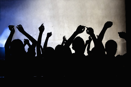 A crowd of young people dancing in a nightclubの写真素材