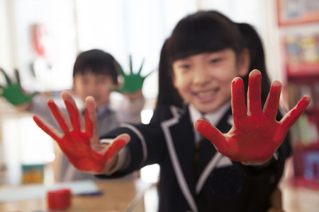School children showing their hands covered in paintの写真素材