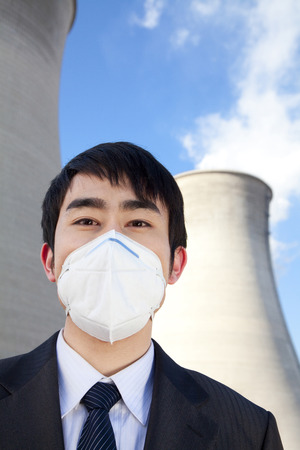 Businessman at power plant with face maskの写真素材