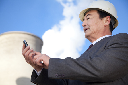 Businessman texting at power plantの写真素材