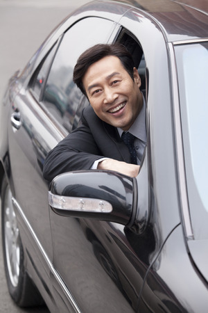Businessman looking out car windowの写真素材