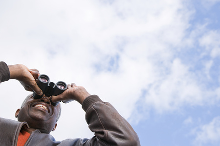 One man looking through binocularsの写真素材