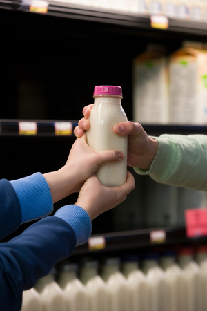 Children holding a bottle of milkの写真素材