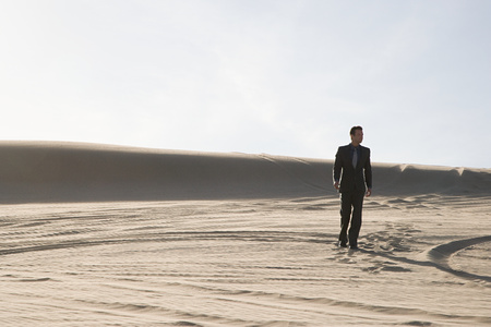 Businessman walking in desertの写真素材