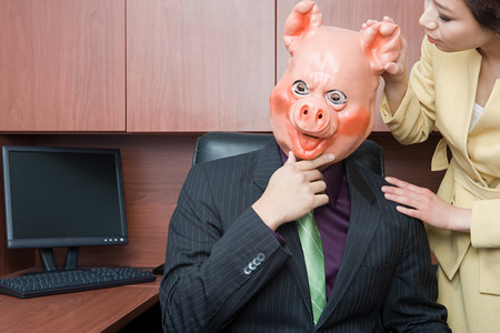 Businessman in pig mask and businesswomanの写真素材