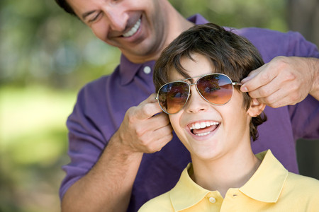 Father putting sunglasses on sonの写真素材