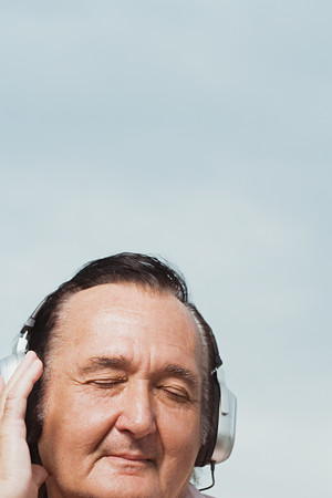 Senior man listening to headphonesの写真素材