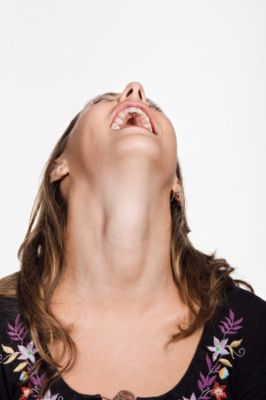 Portrait of young woman with her head back laughingの写真素材