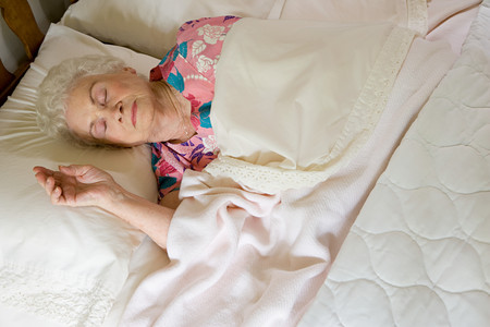 Elderly woman asleep in bedの写真素材